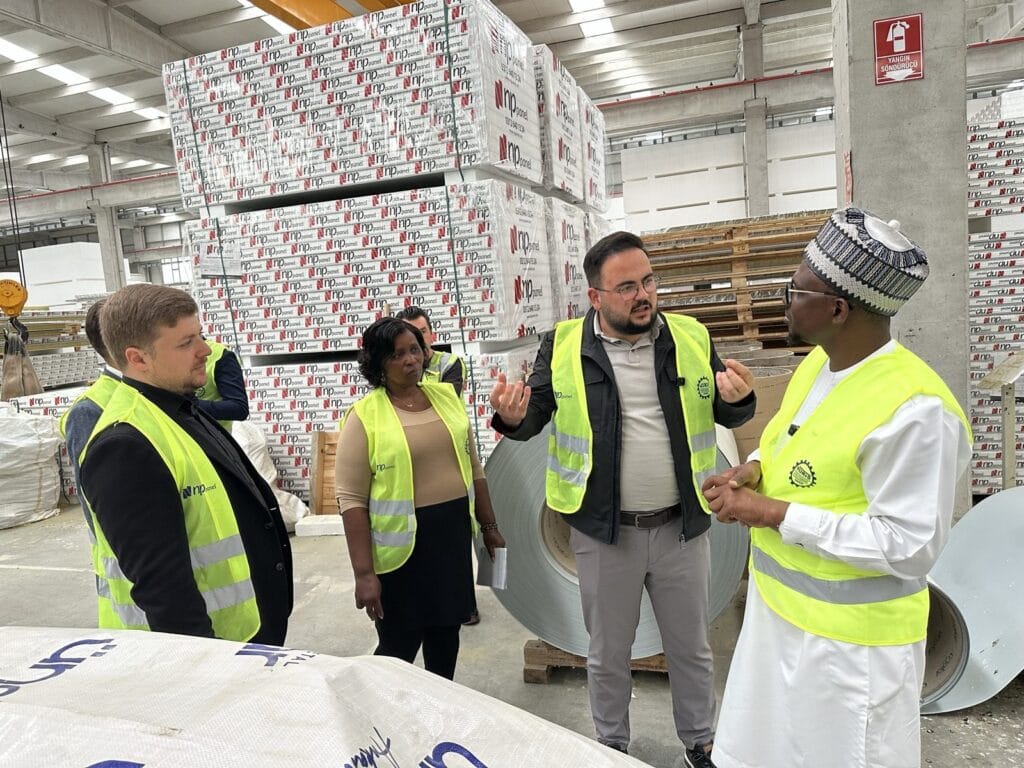 Sandviç panel paketleri önünde üretim süreci anlatılırken